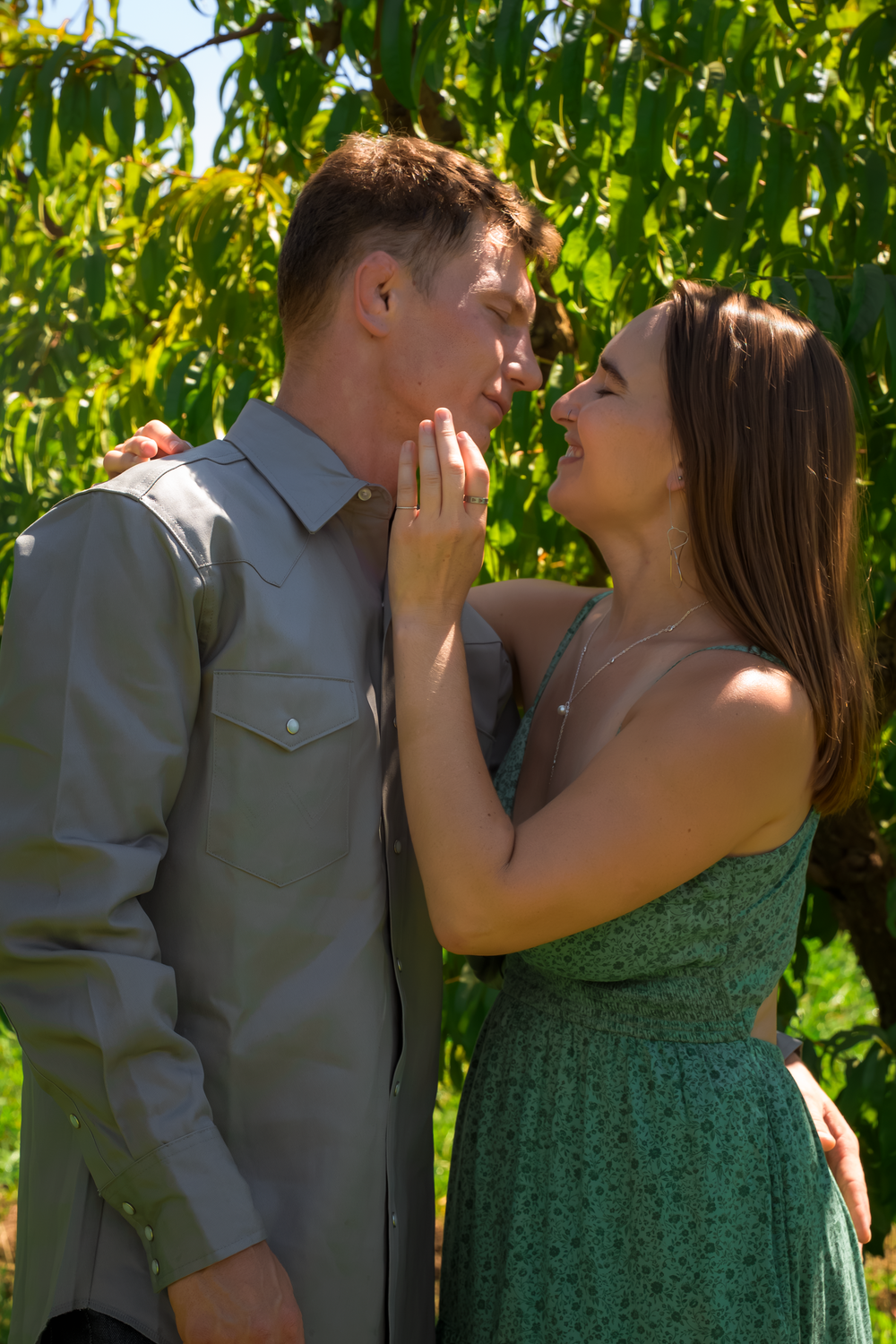 A romantic moment captured between two people in a lush green garden setting.