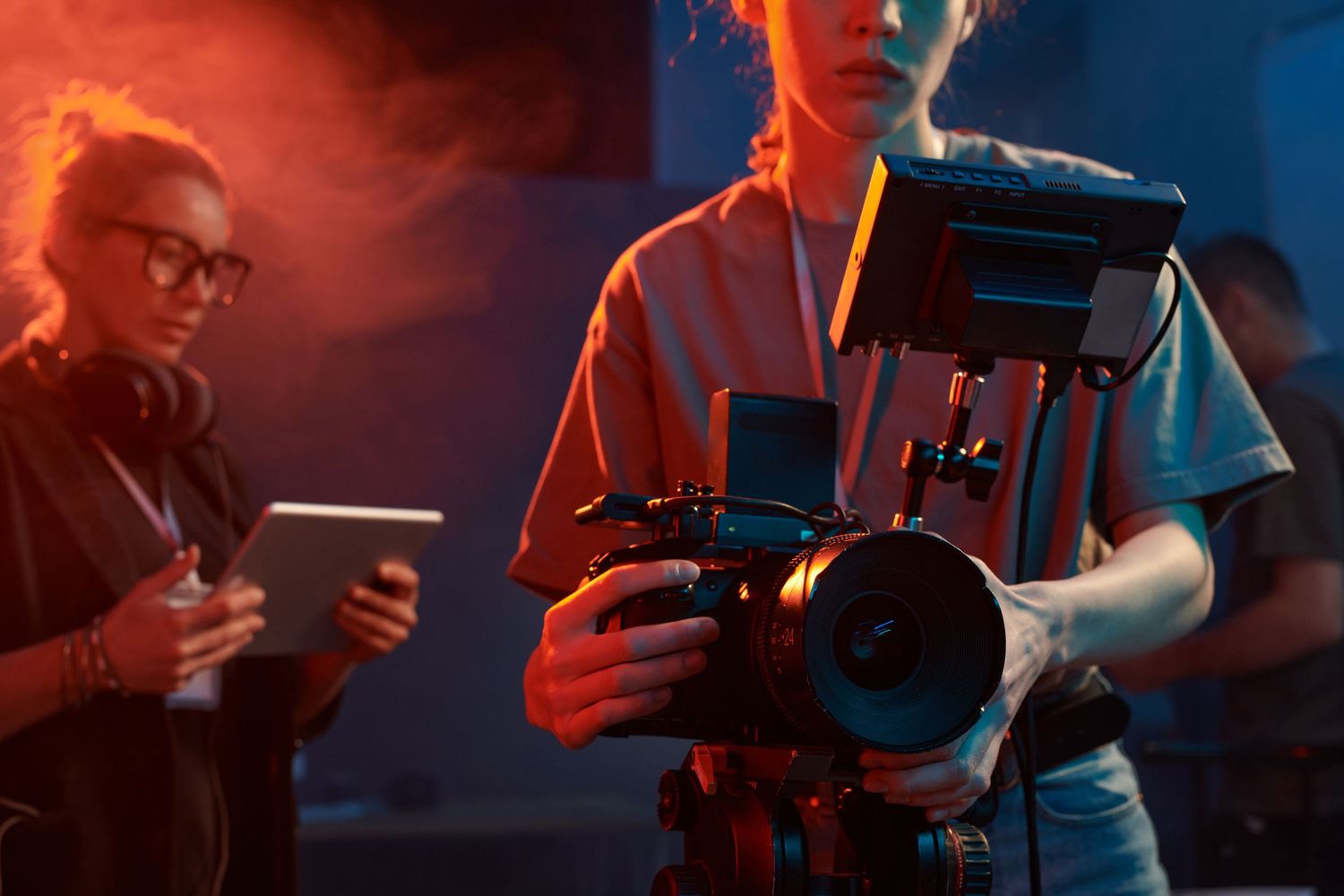 Musicians on stage perform in dramatic red and blue lighting during a live concert performance.