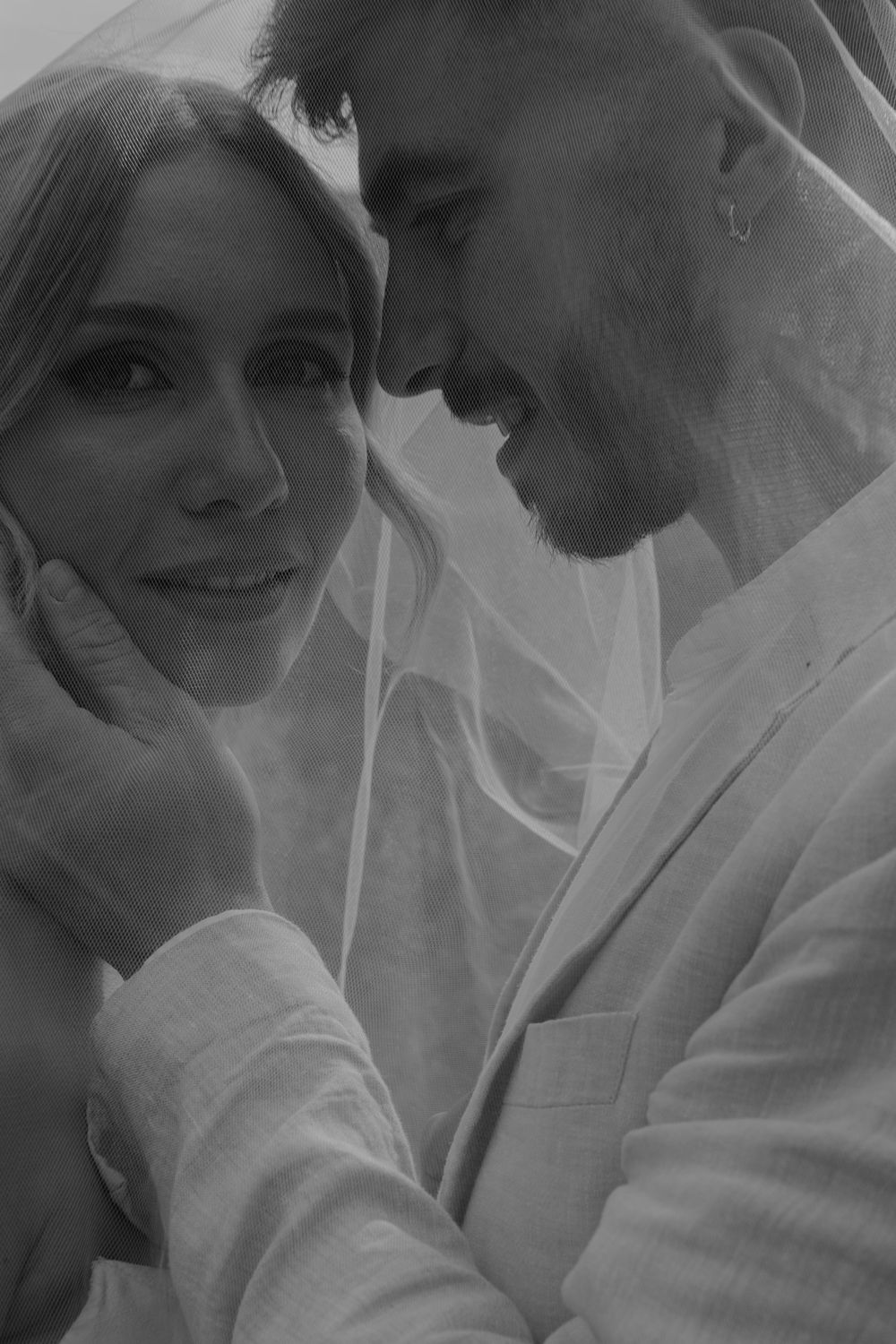 A romantic black and white wedding portrait with soft lighting.