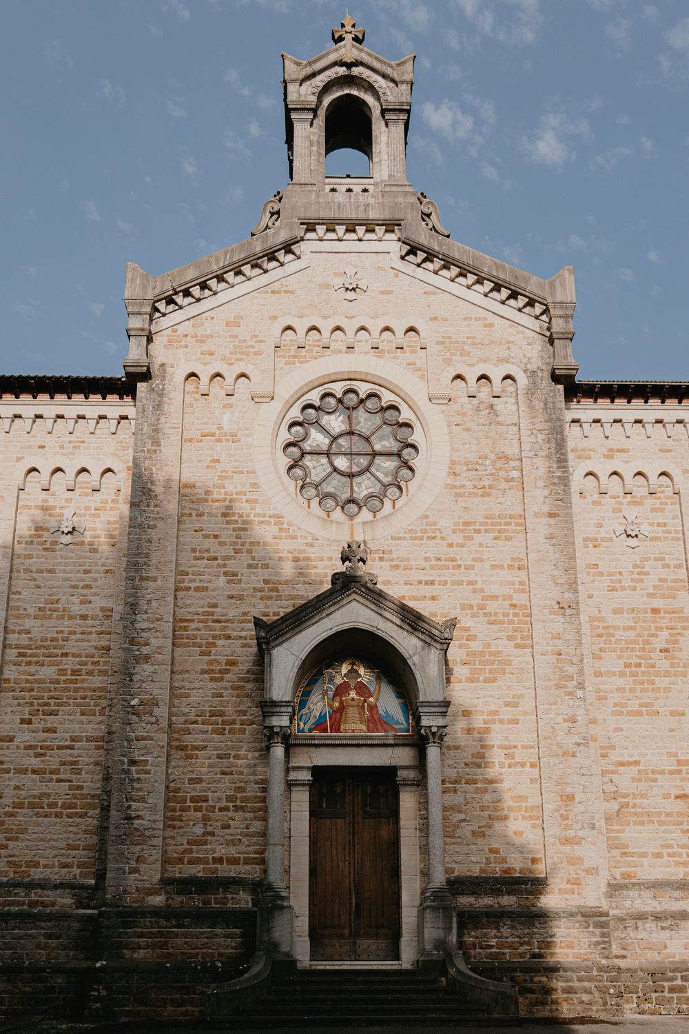 Exterior view of a beautiful stone church with Romanesque architecture and ornate details.