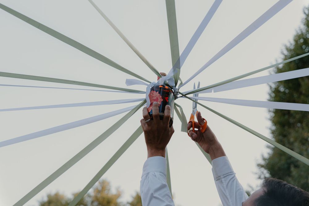Abstract view of a white parasol or umbrella frame shot from below against a bright sky.