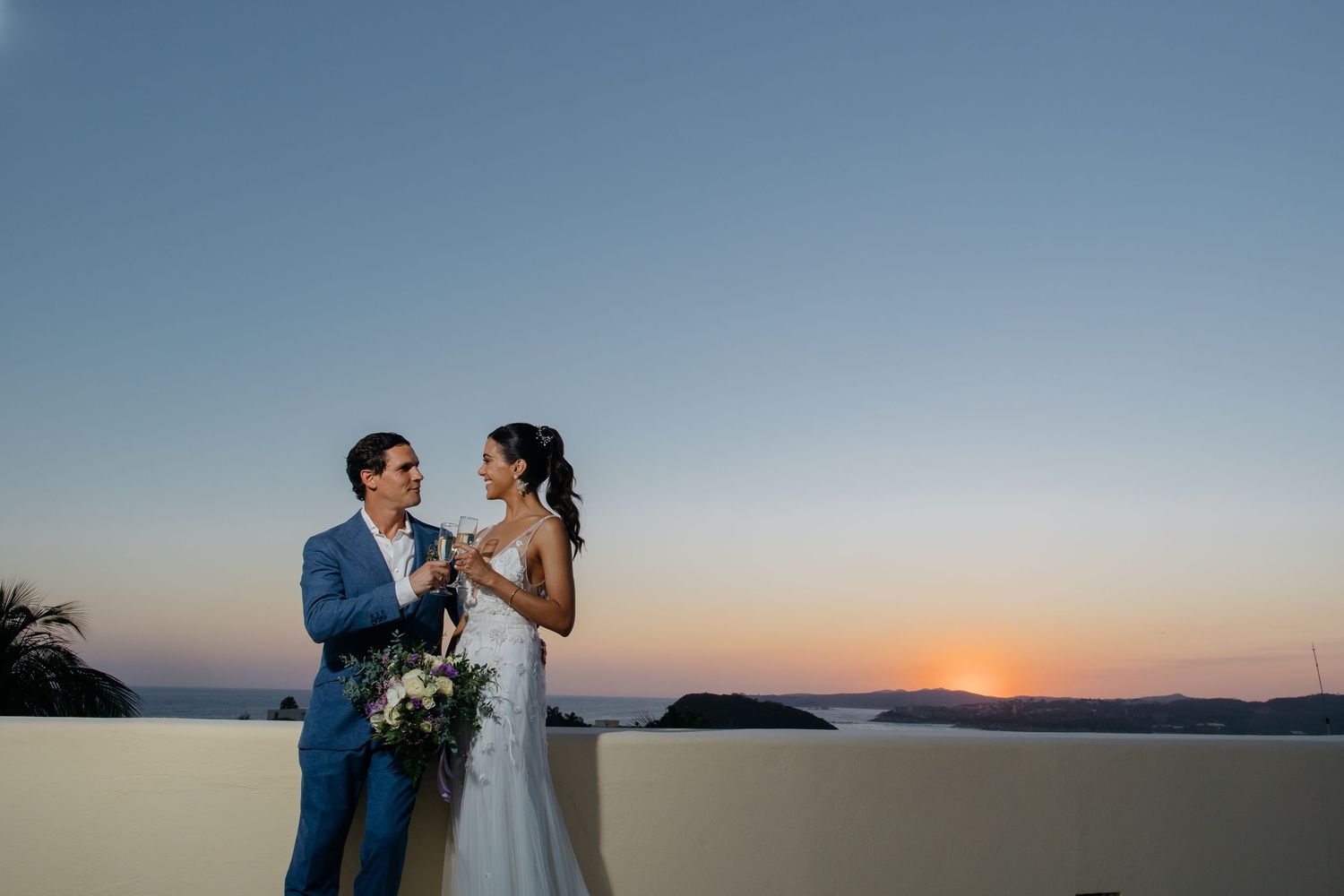 Romantic sunset wedding photos captured against a dramatic coastal skyline.