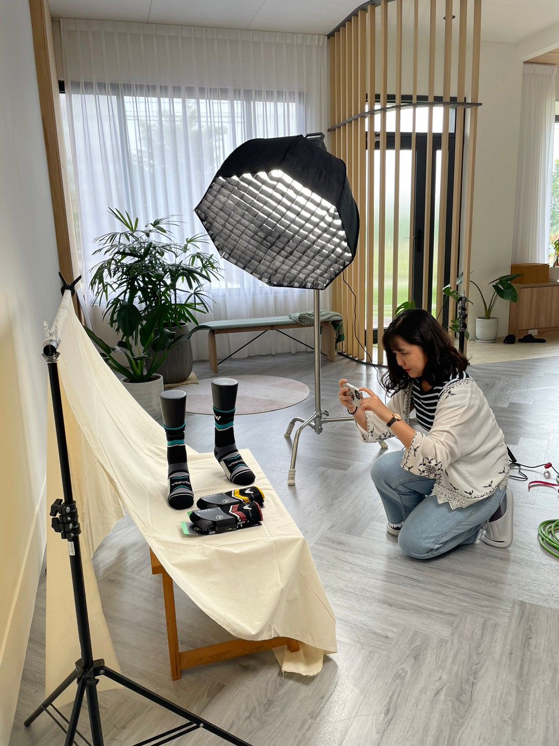 Behind-the-scenes photo shoot setup showing professional lighting equipment in a bright modern studio space.