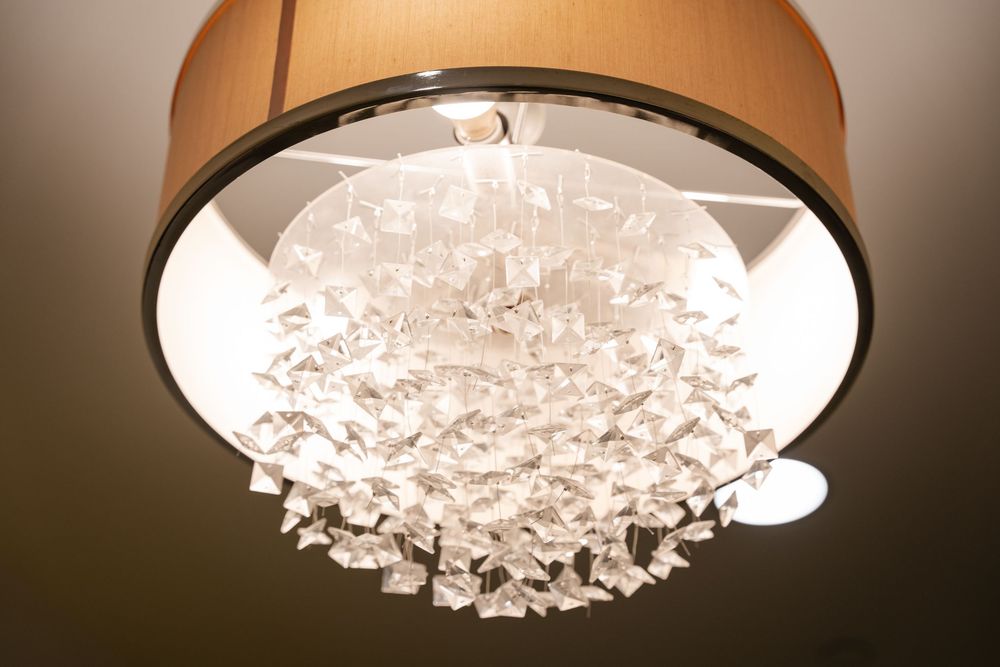 Crystal chandelier with cascading glass elements illuminated from above creates a luxurious lighting effect.