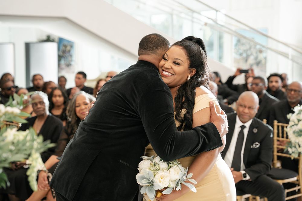 Two individuals share an intimate dance moment at what appears to be a wedding reception or formal event.
