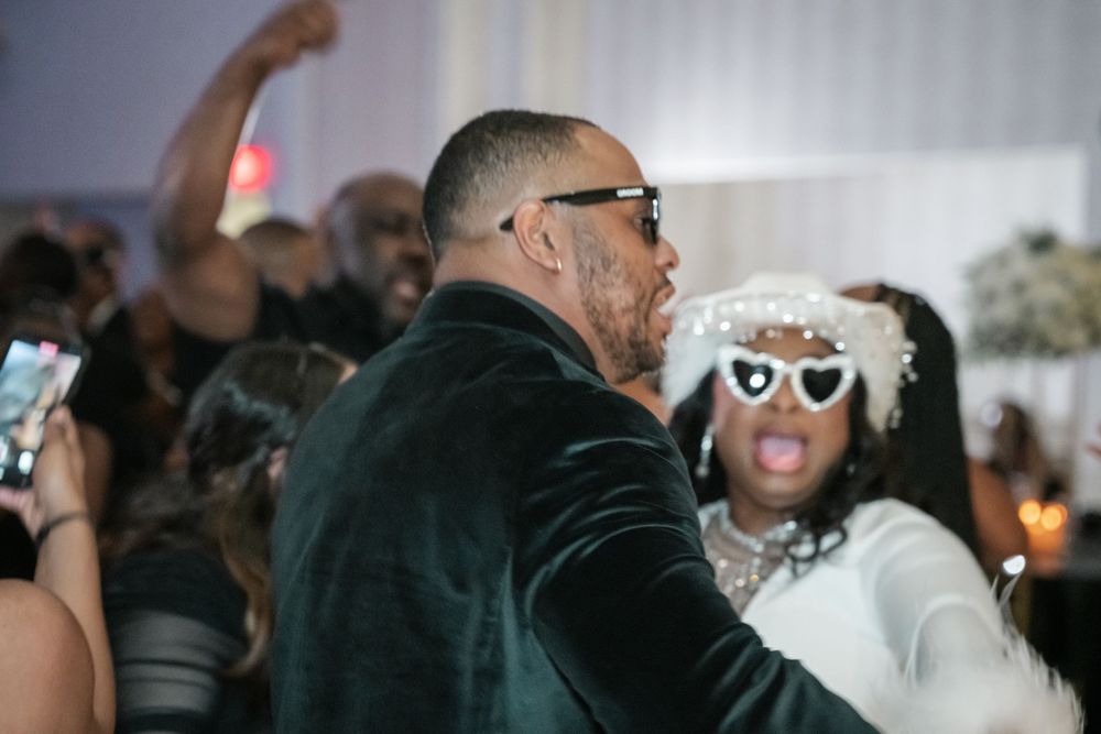 A festive crowd enjoys a wedding reception dance party with energetic celebrations.