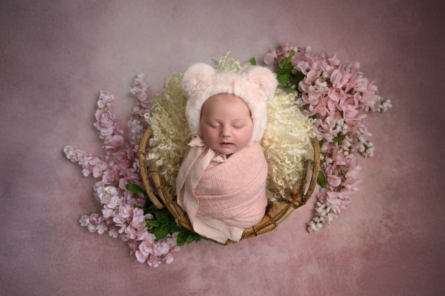 Artistic series of six pink and cream toned newborn portraits with blossoms and floral decorative elements.