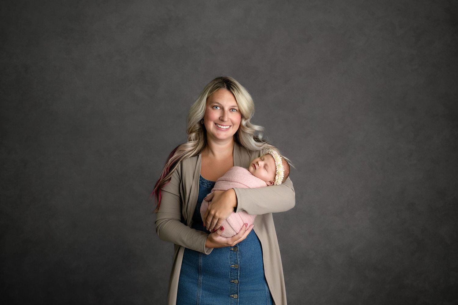 Professional studio photography session showing heartwarming family moments against a dark gray backdrop.
