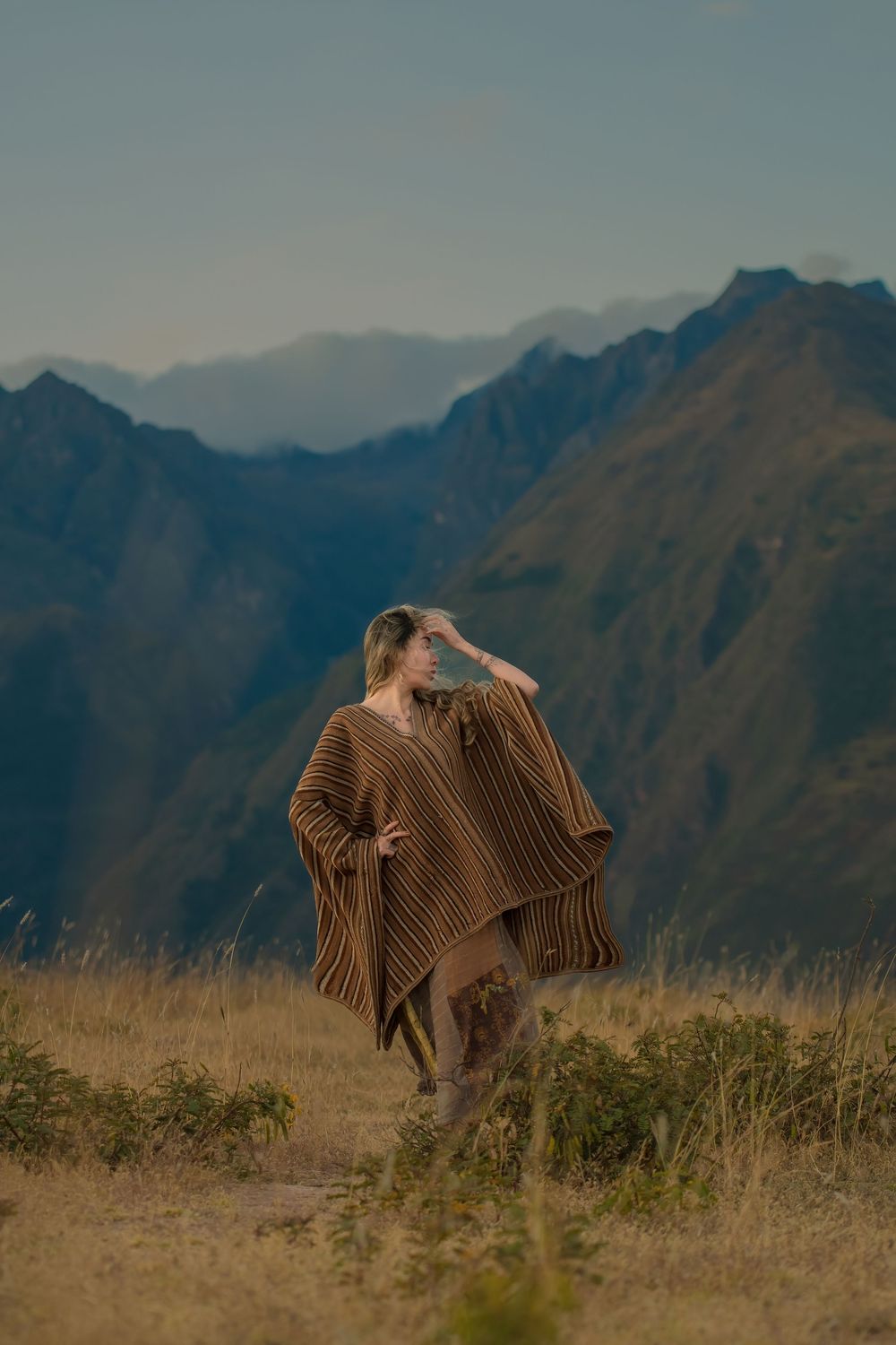 Andean condors spread their massive wings against a backdrop of rugged mountain peaks in Peru.