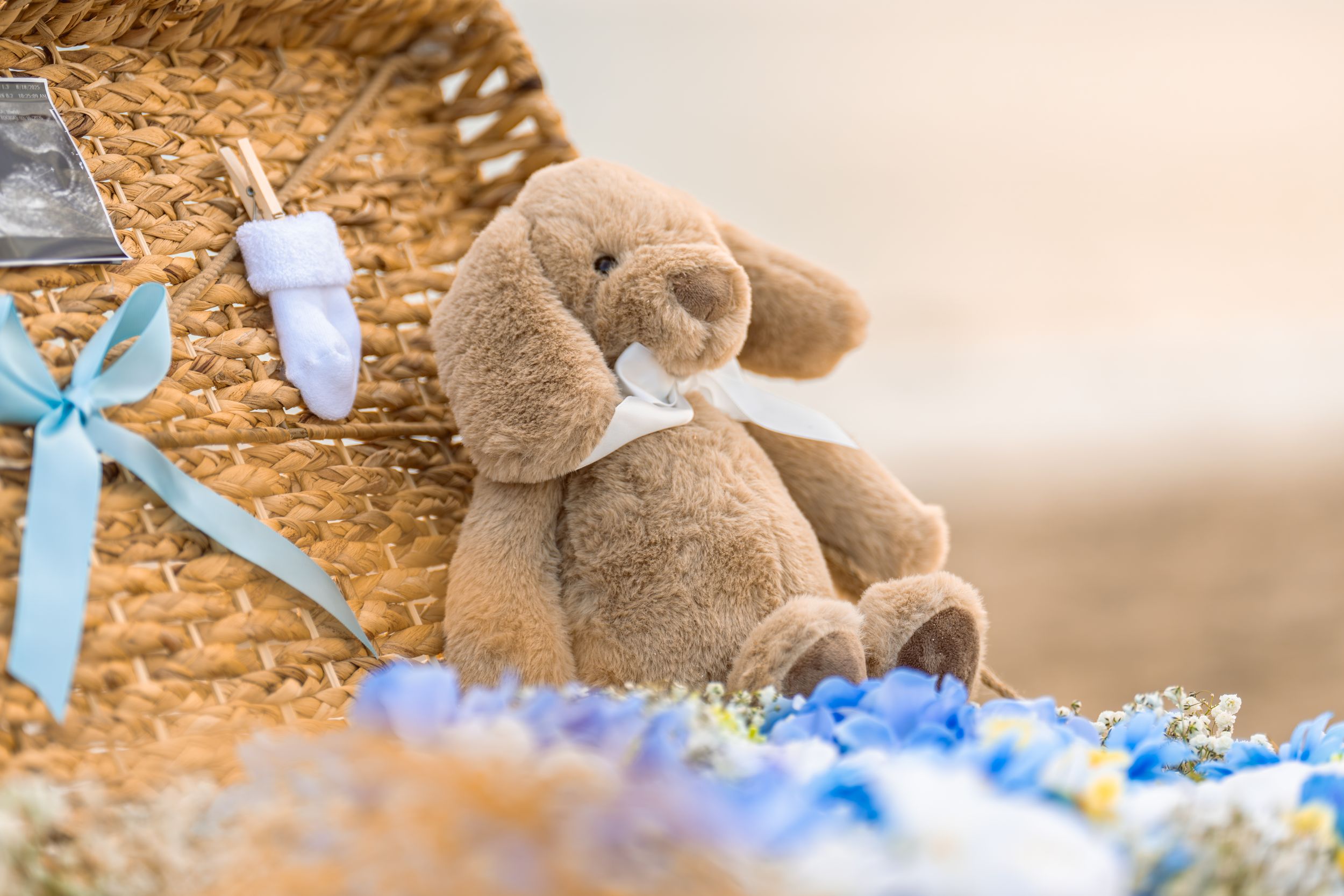 Decorative stuffed teddy bears arranged with blue ribbons on textured golden background.