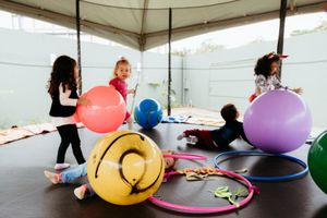 People exercising and stretching using colorful exercise stability balls in a fitness studio.
