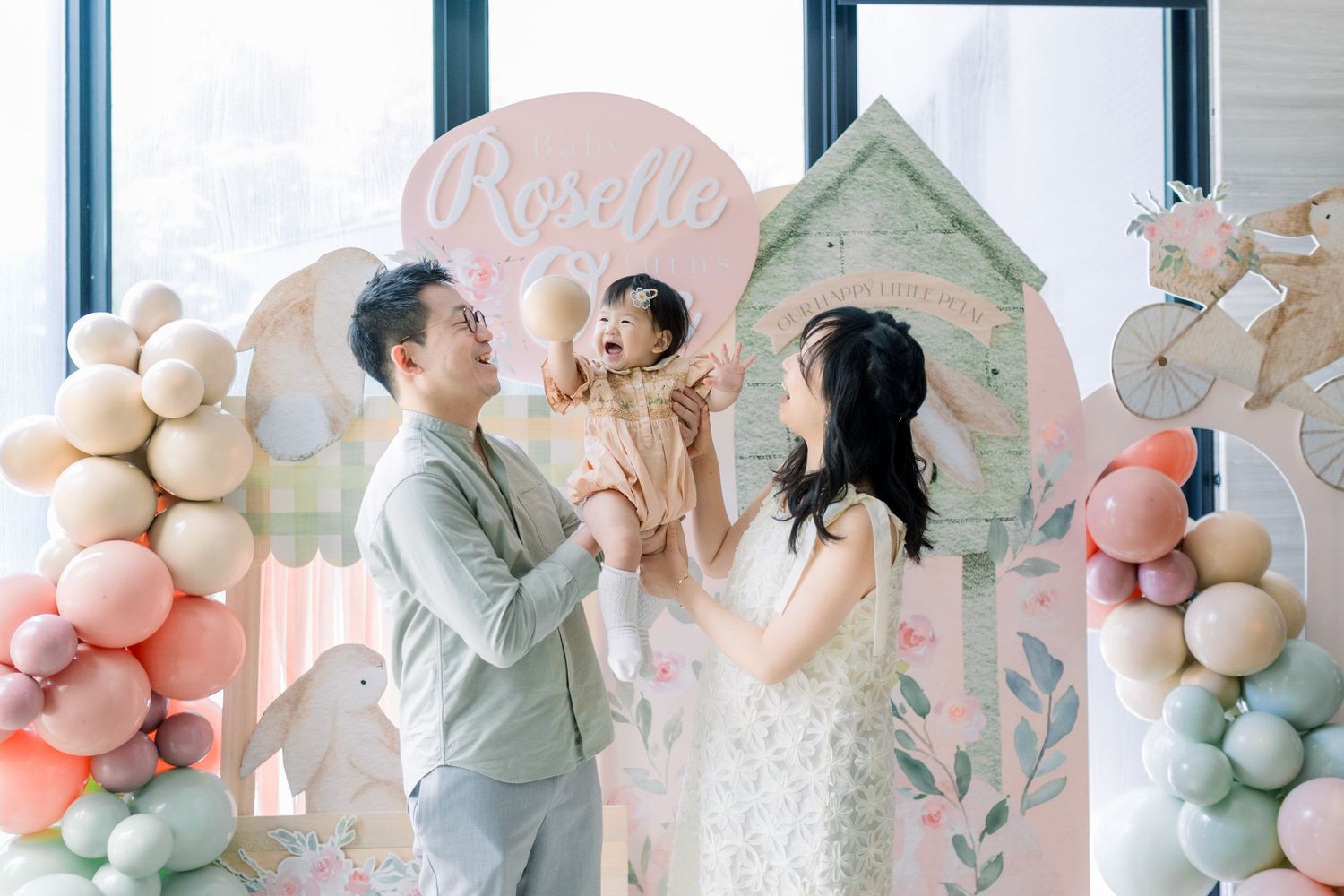 Party decorations featuring pastel balloon arches, floral designs and delicate accents create an elegant celebration setting.