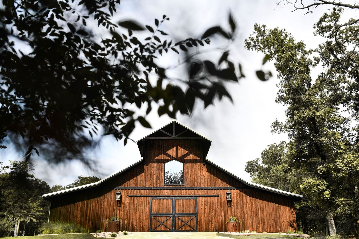 Dreamy modern barn set among mature trees for a natural wedding backdrop at whispering oaks wedding venue
