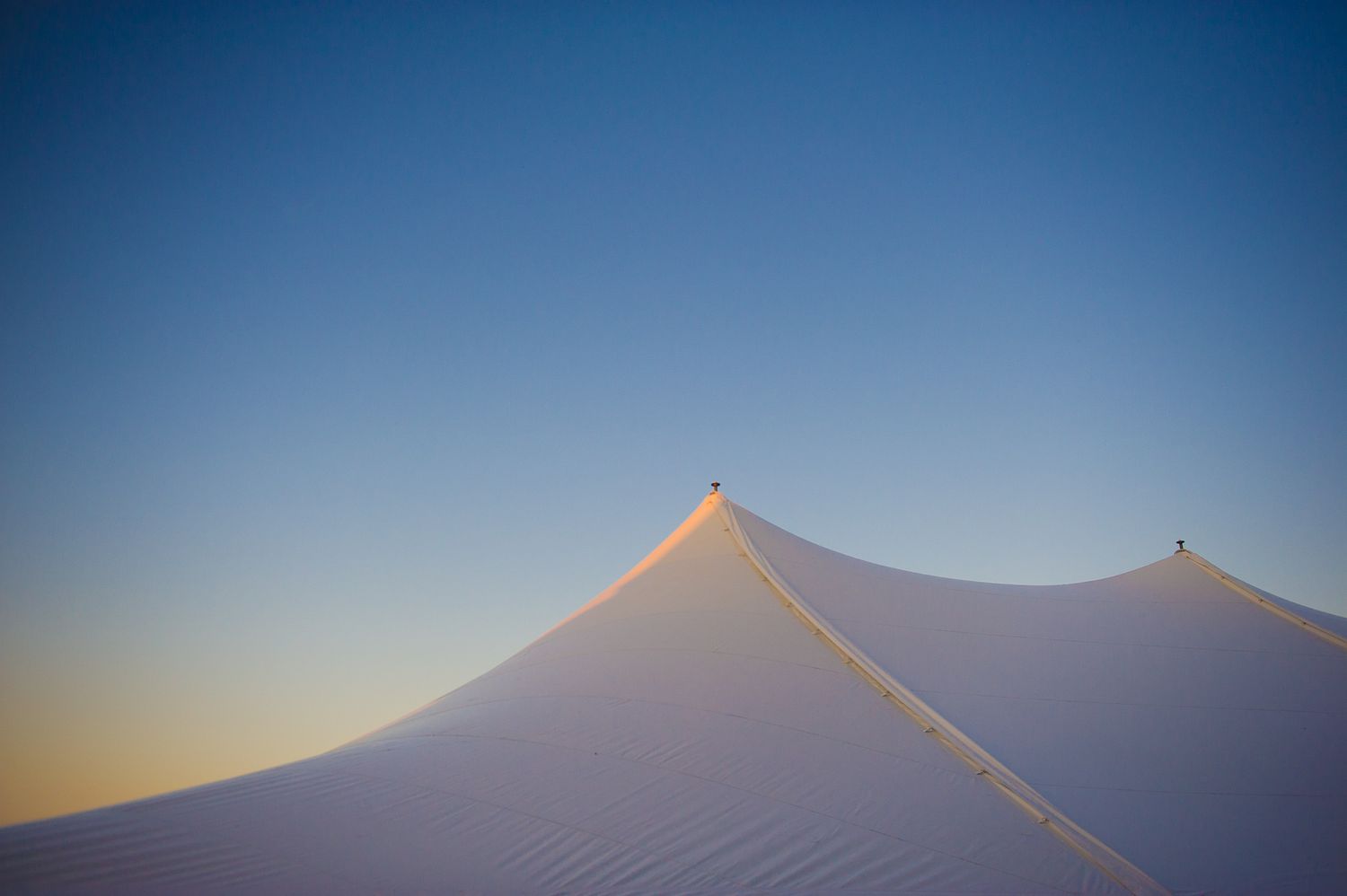 Minimalist wedding tent photo in a clear twilight sky with artistic framing