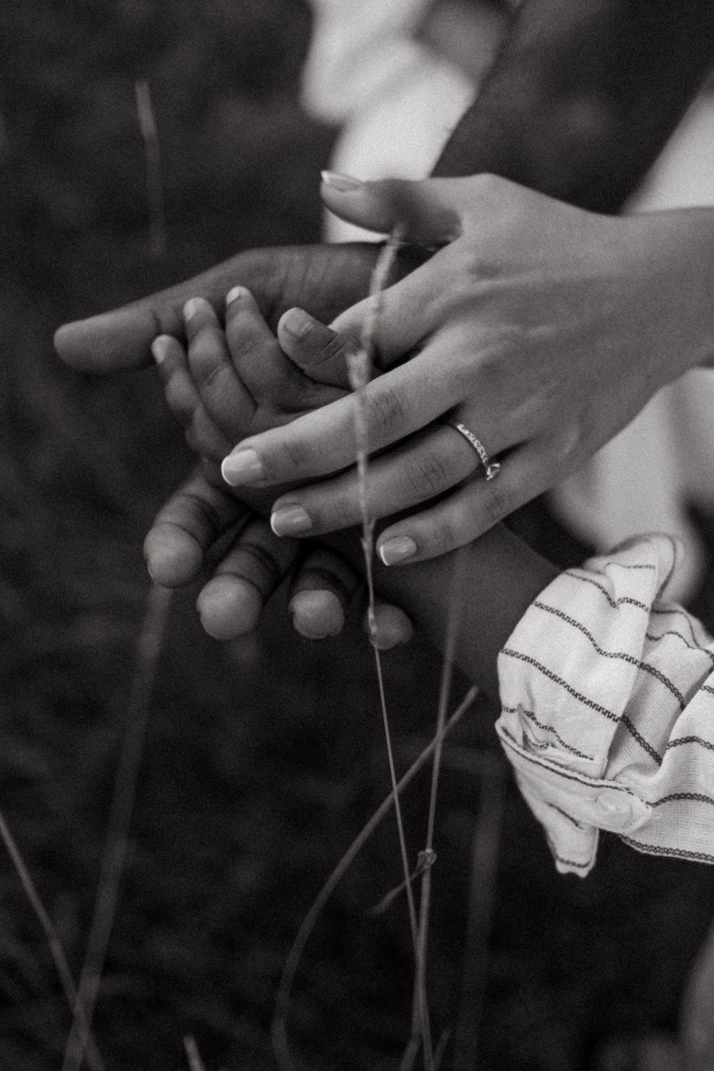 detail shot of hands of a mom, dad and toddler son being captured by outdoor family photographer in Stockholm