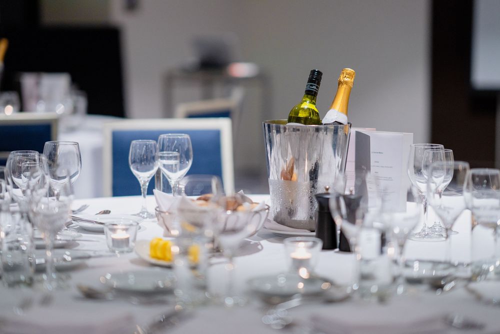 Elegant table settings with wine glasses and place settings await dinner guests in a formal dining room.