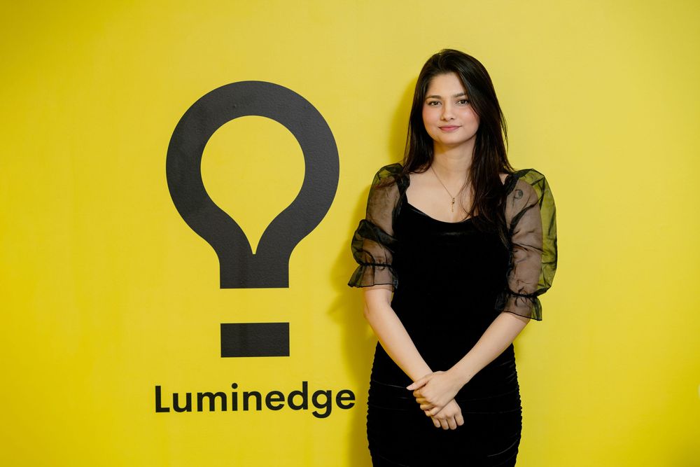 Professional portraits against bright yellow backdrop show figure in black outfit posing with dynamic angles and expressions.