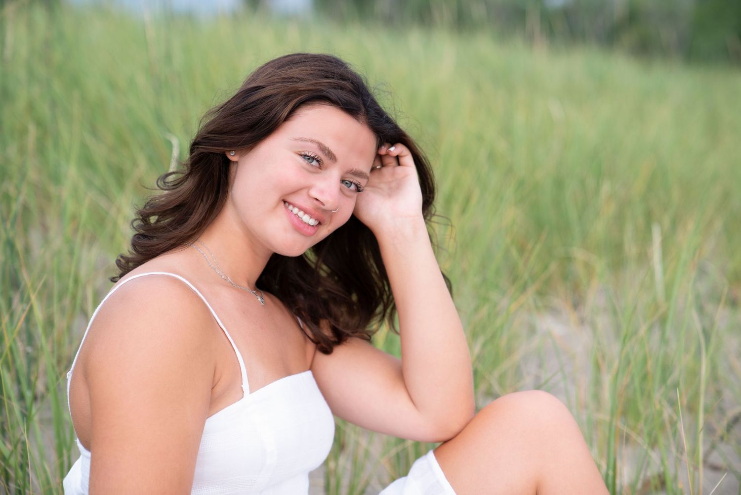 A series of outdoor portrait photographs showing poses in a grass field against a natural background.