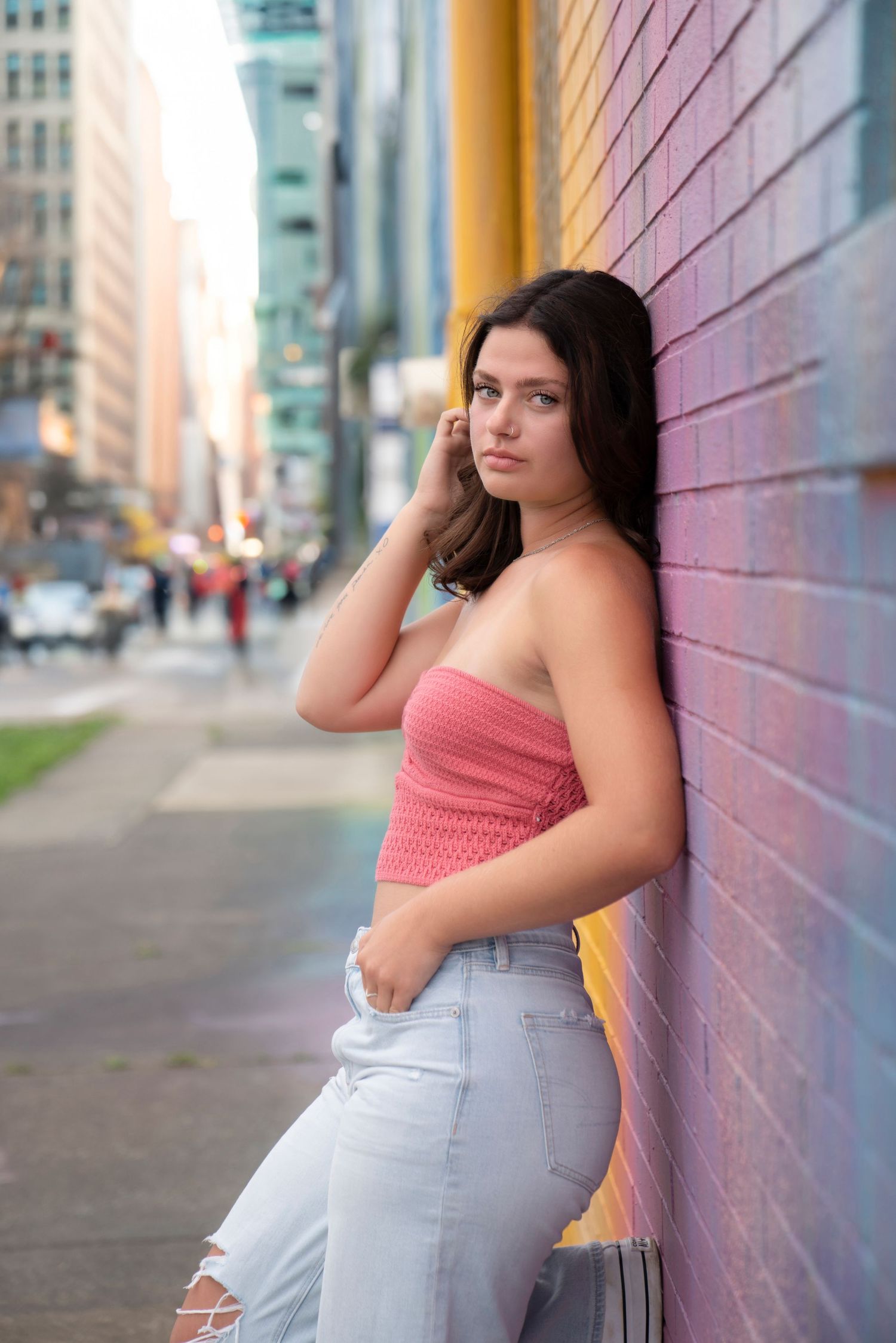Four candid street style fashion poses against an urban wall showcasing casual summer attire and natural lighting.