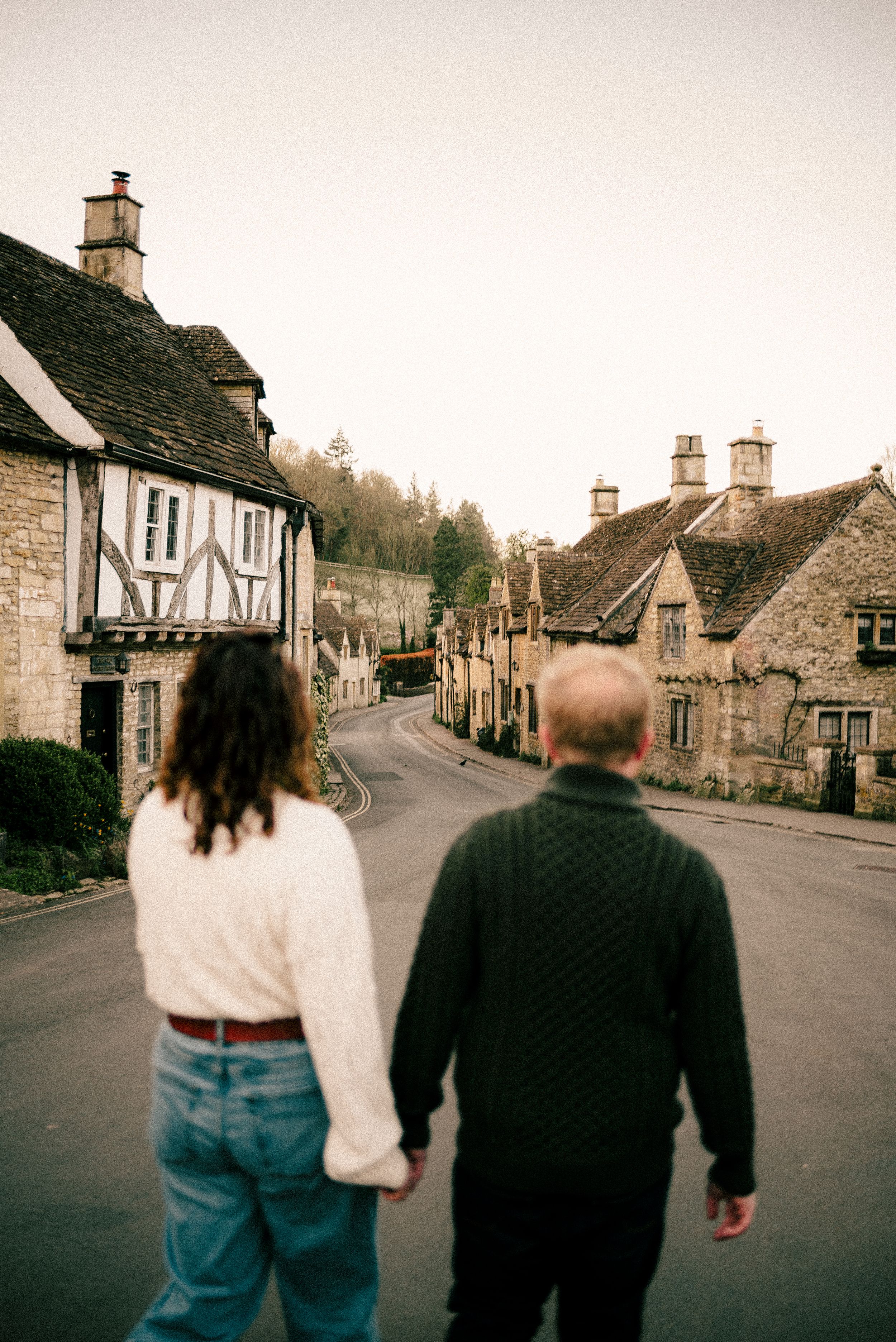 A quiet village street lined with historic stone cottages and traditional architecture in England.