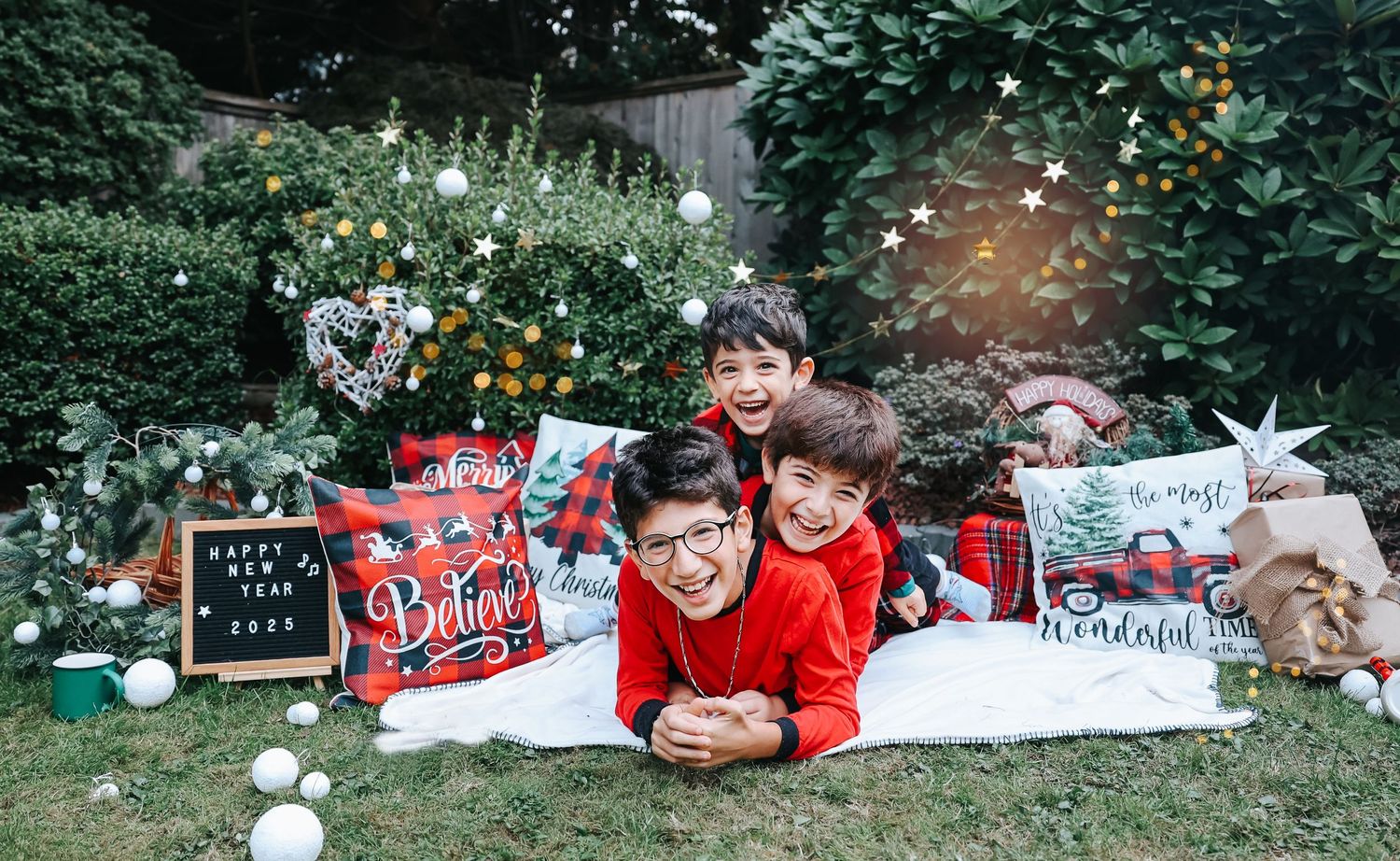 Holiday themed outdoor photo setup with Christmas decorations and festive props on grass.
