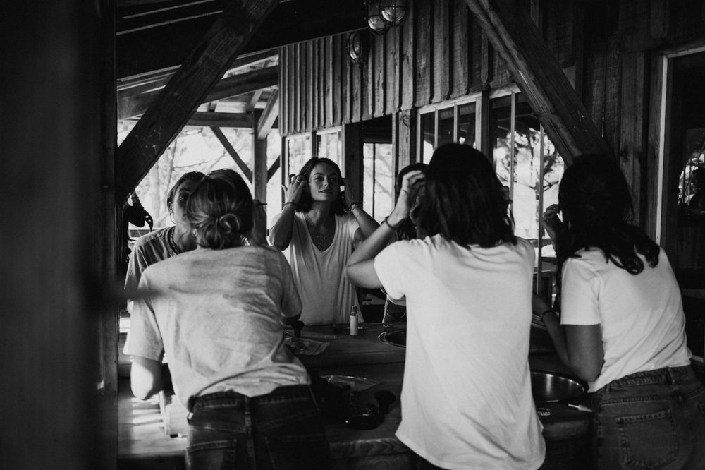 Black and white image of a group gathered at a rustic wooden bar counter.