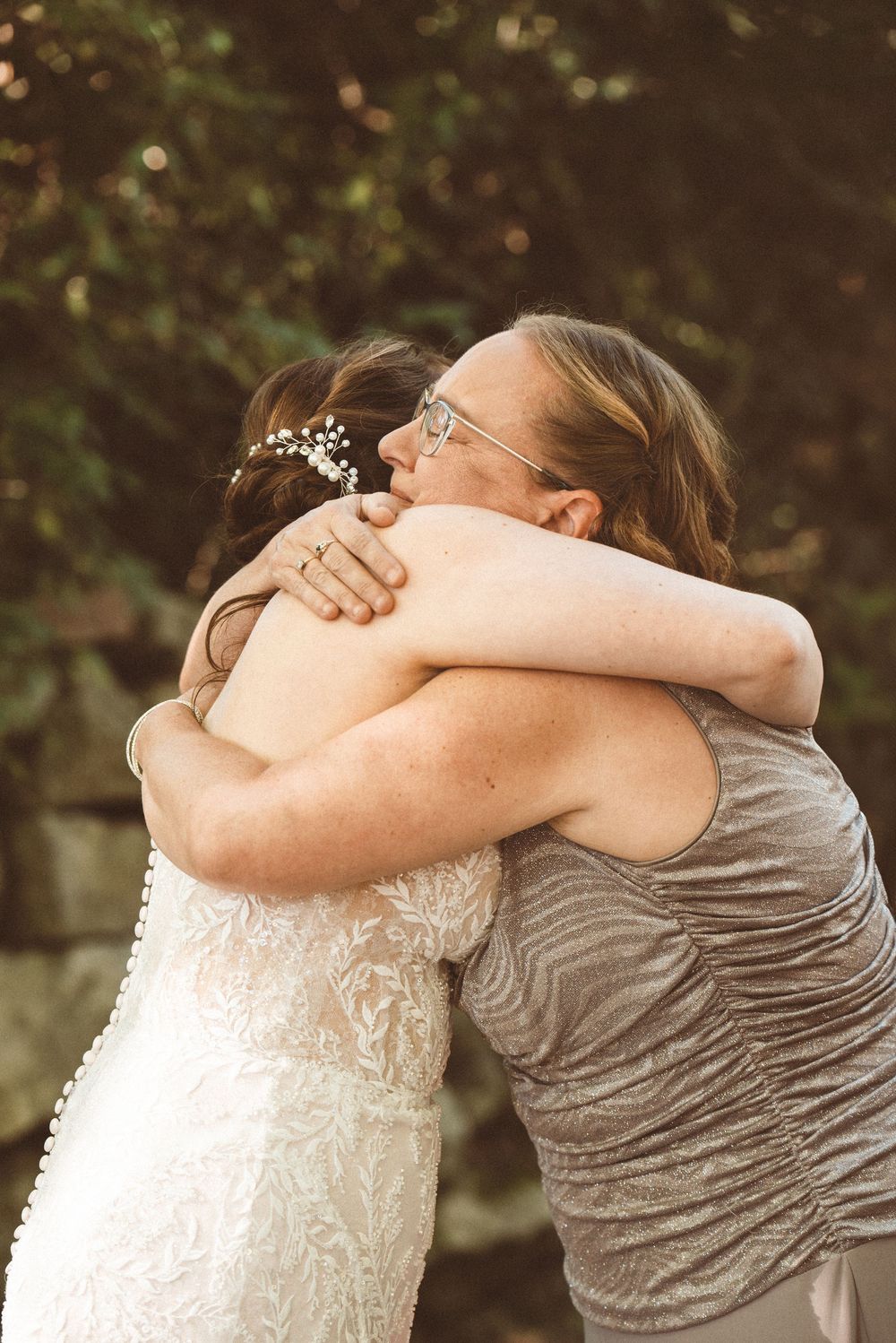 A picture of an emotional moment between a mother and bride hugging on her wedding day.