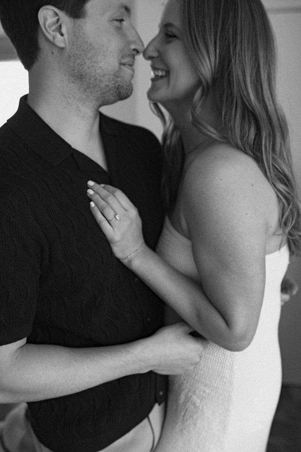 A romantic black and white portrait of a couple sharing an intimate moment in an embrace.