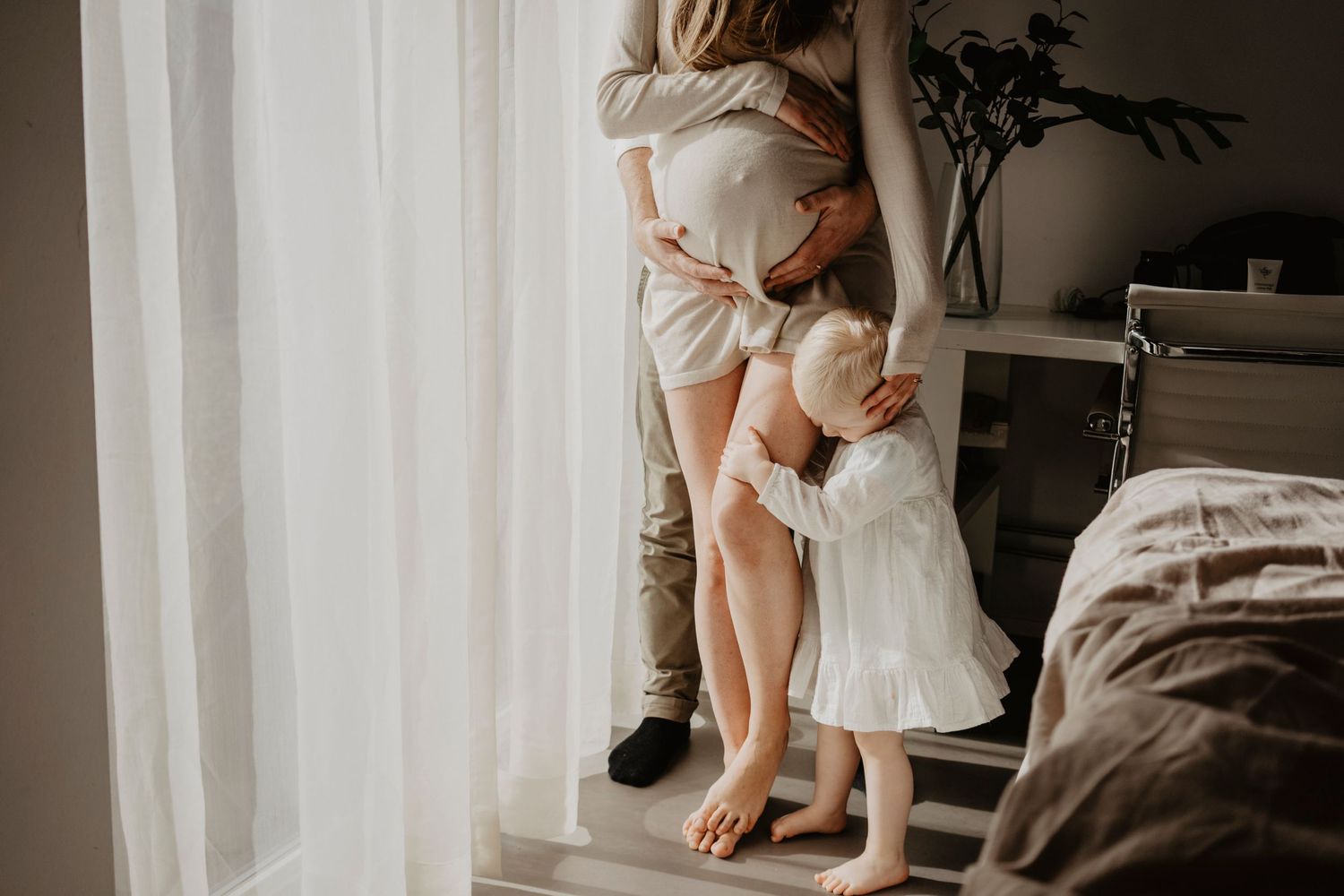 Sessão de gravidez em casa na Grande Lisboa. Fotografia emocional e natural que capta ligação familiar e ternura entre mãe e filha.