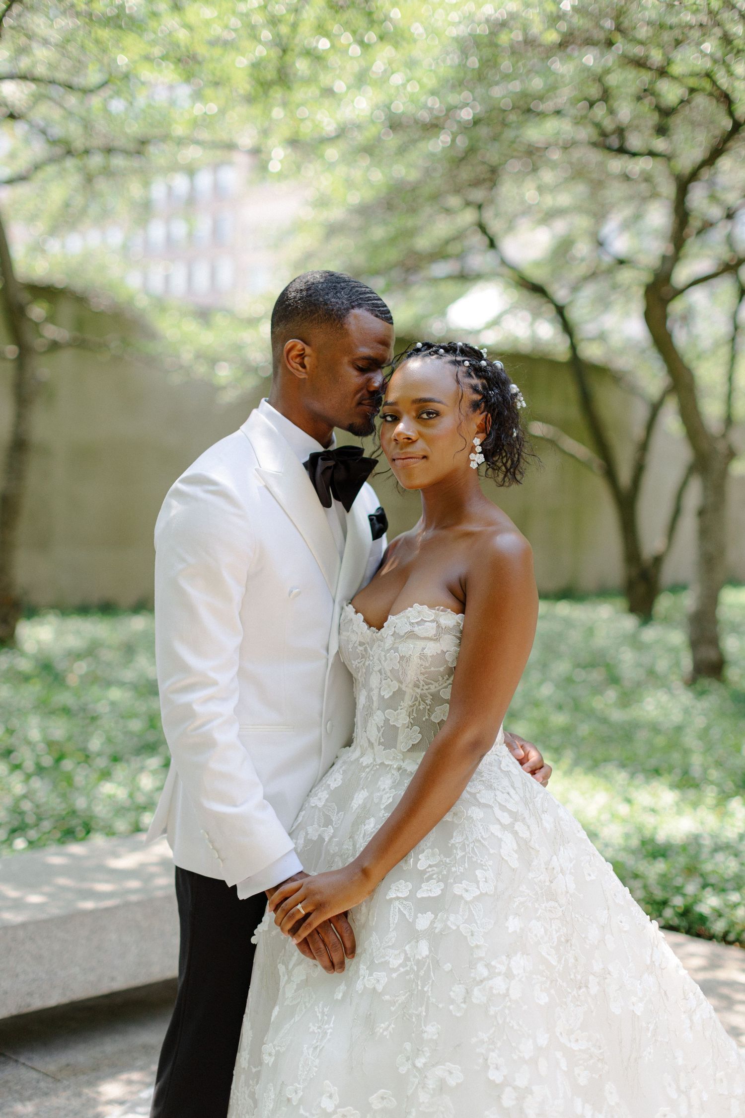 Intimate wedding portrait in garden with detailed lace gown.