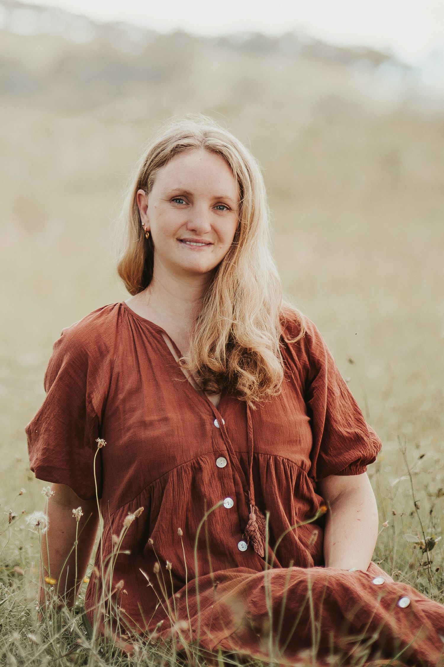Canberra family photographer Ellen posing in a field