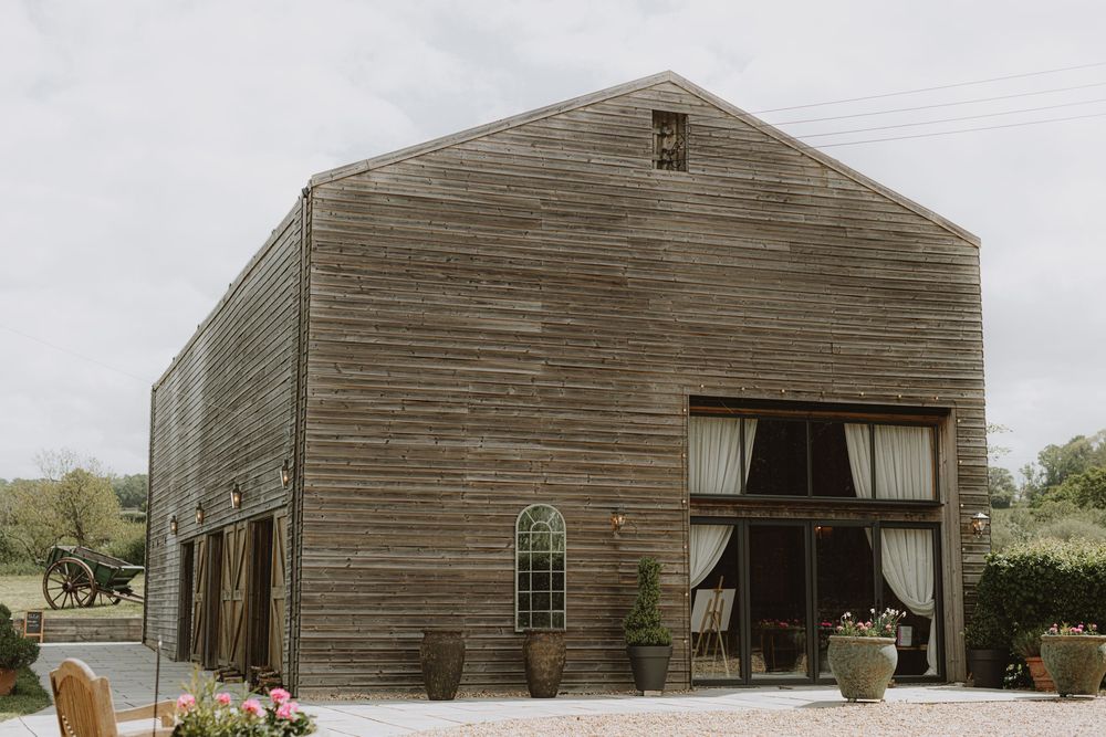 Exterior view of a rustic wooden barn venue with weathered siding.