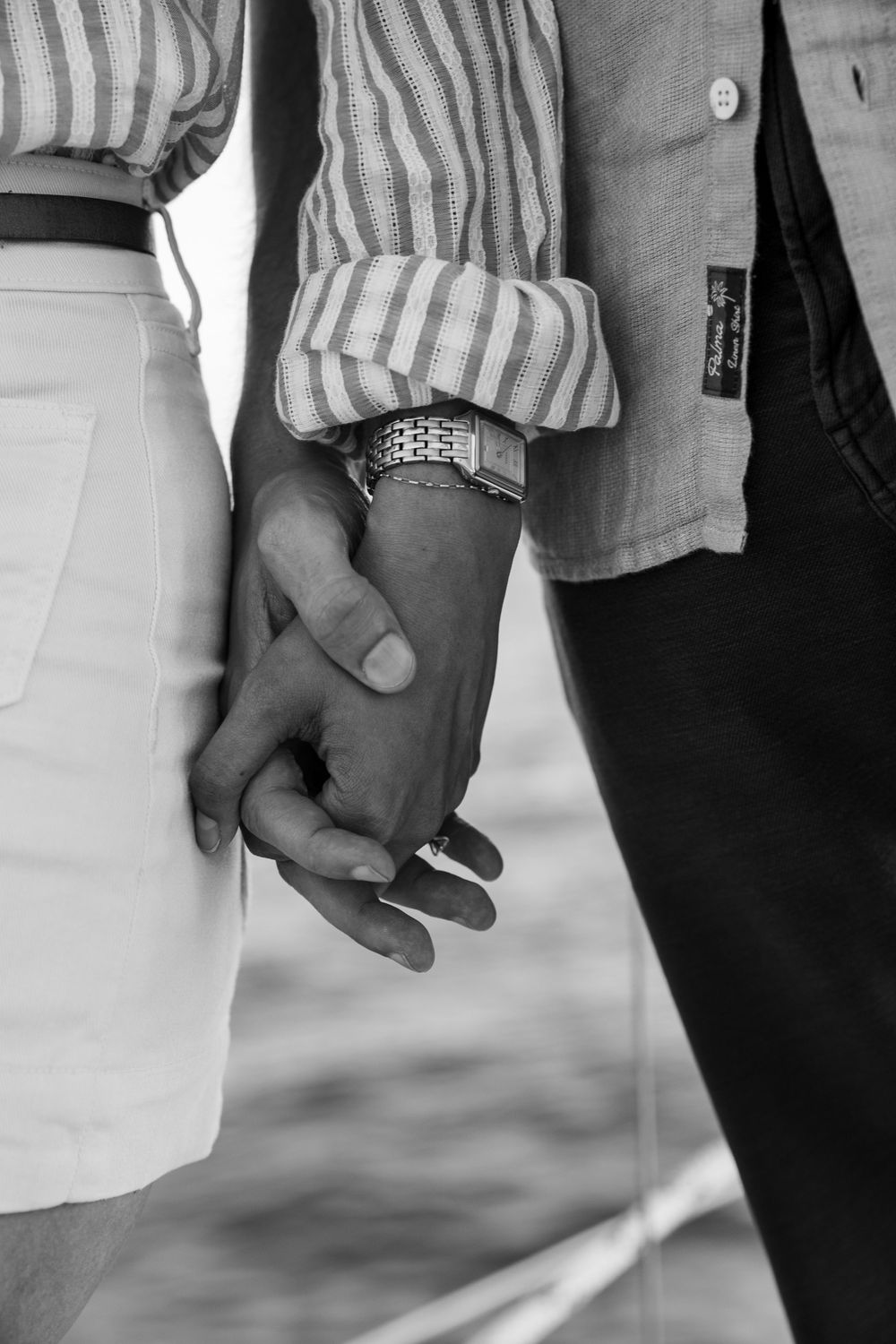 A series of black and white photographs showing close-up views of couples holding hands in different poses.