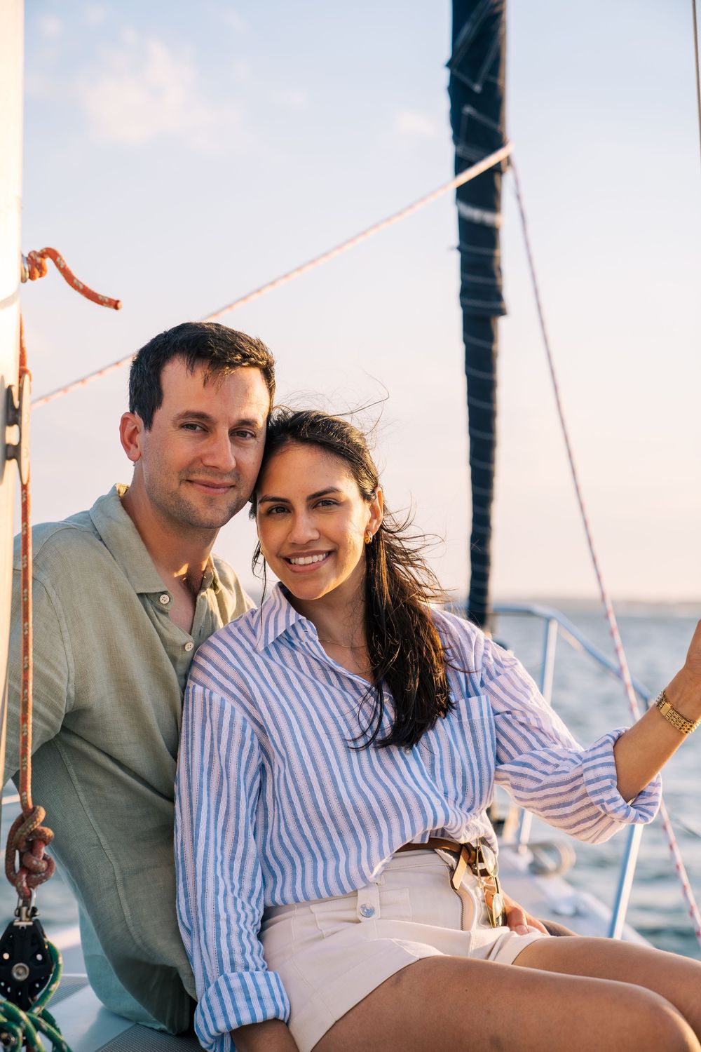 A couple enjoys a romantic moment together while sailing on a boat at sea during sunset.