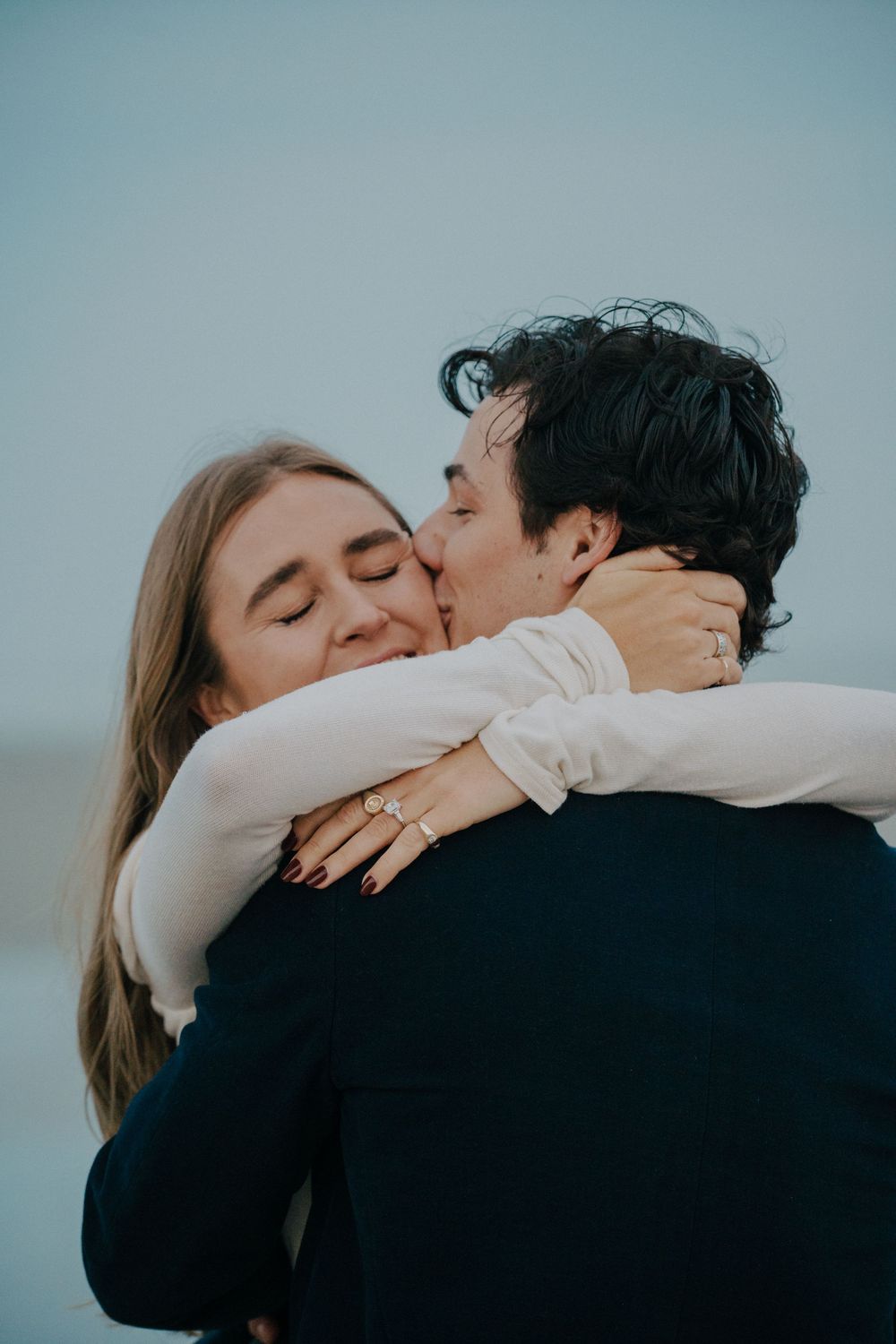 Romantic couple sharing intimate embraces and kisses in a sequence of moody blue-tinted photographs.