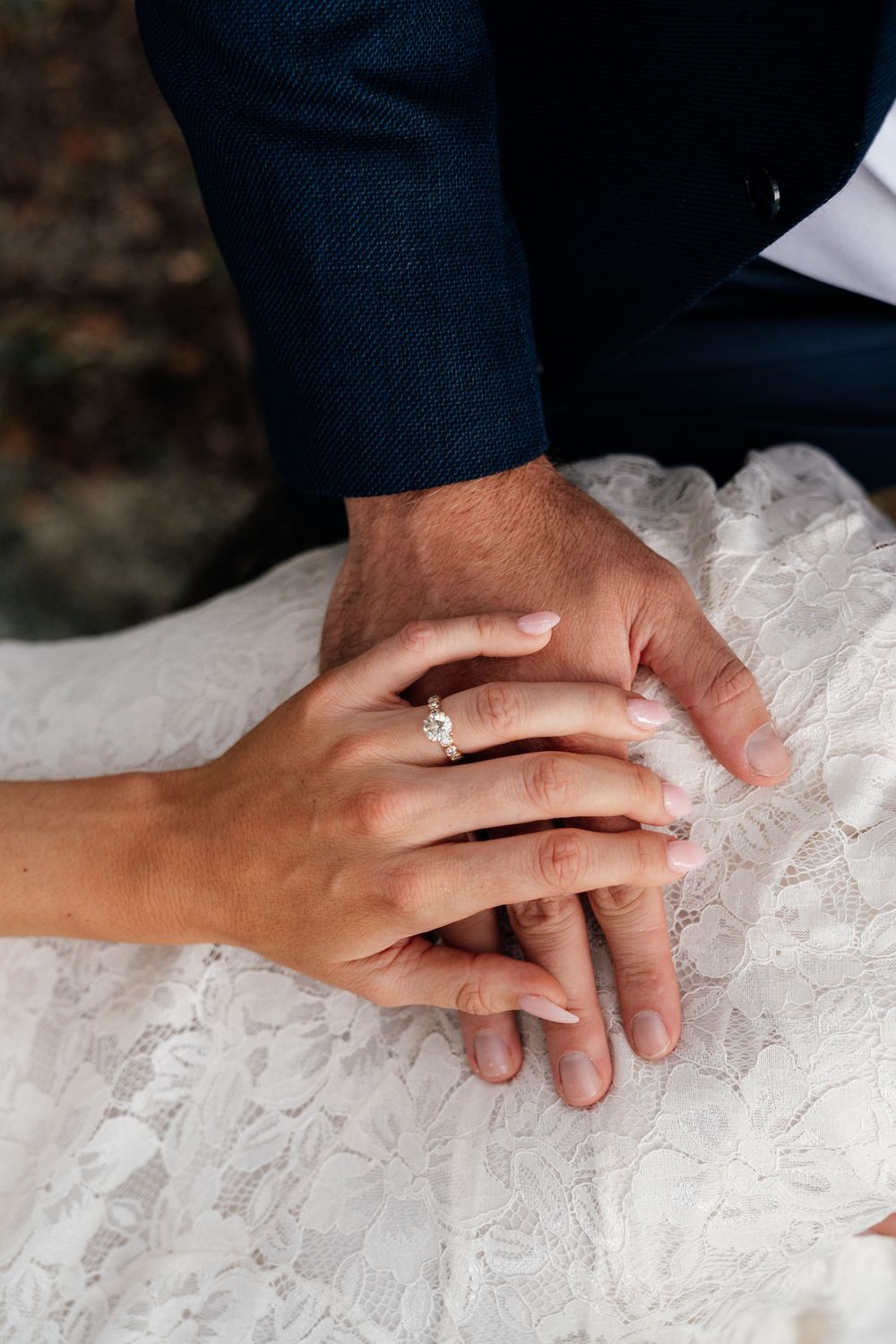 Close-up sequence of hands with wedding rings resting on white lace fabric showing tender moments of touch.