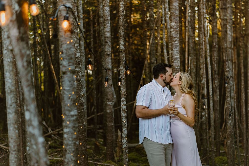 A romantic couple embraces in a sunlit birch forest at golden hour, creating a magical woodland atmosphere.