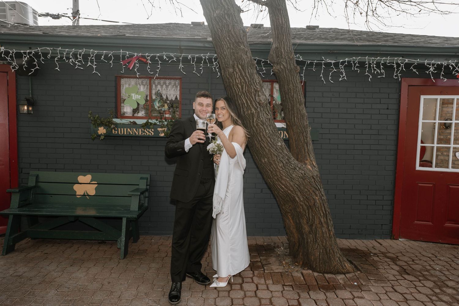 Bride and groom share intimate dance moments at an outdoor reception beneath strung cafe lights at dusk.