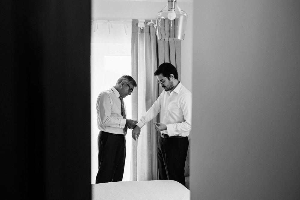 Black and white image of two people getting ready in a bright room.