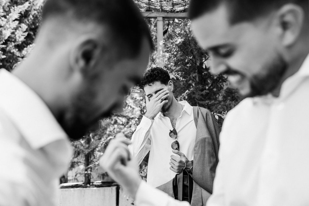 A couple is outdoors in their wedding attire sharing an intimate moment against a natural background.