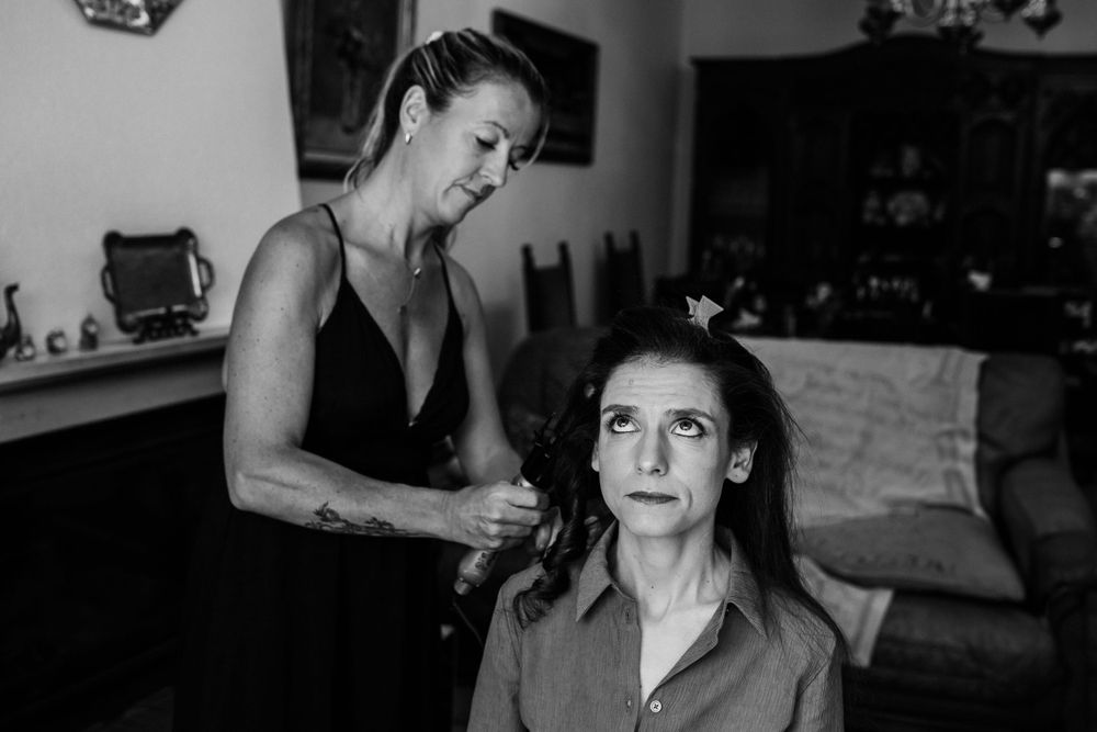 A black and white photo showing preparation of a woman's hair for a special occasion.