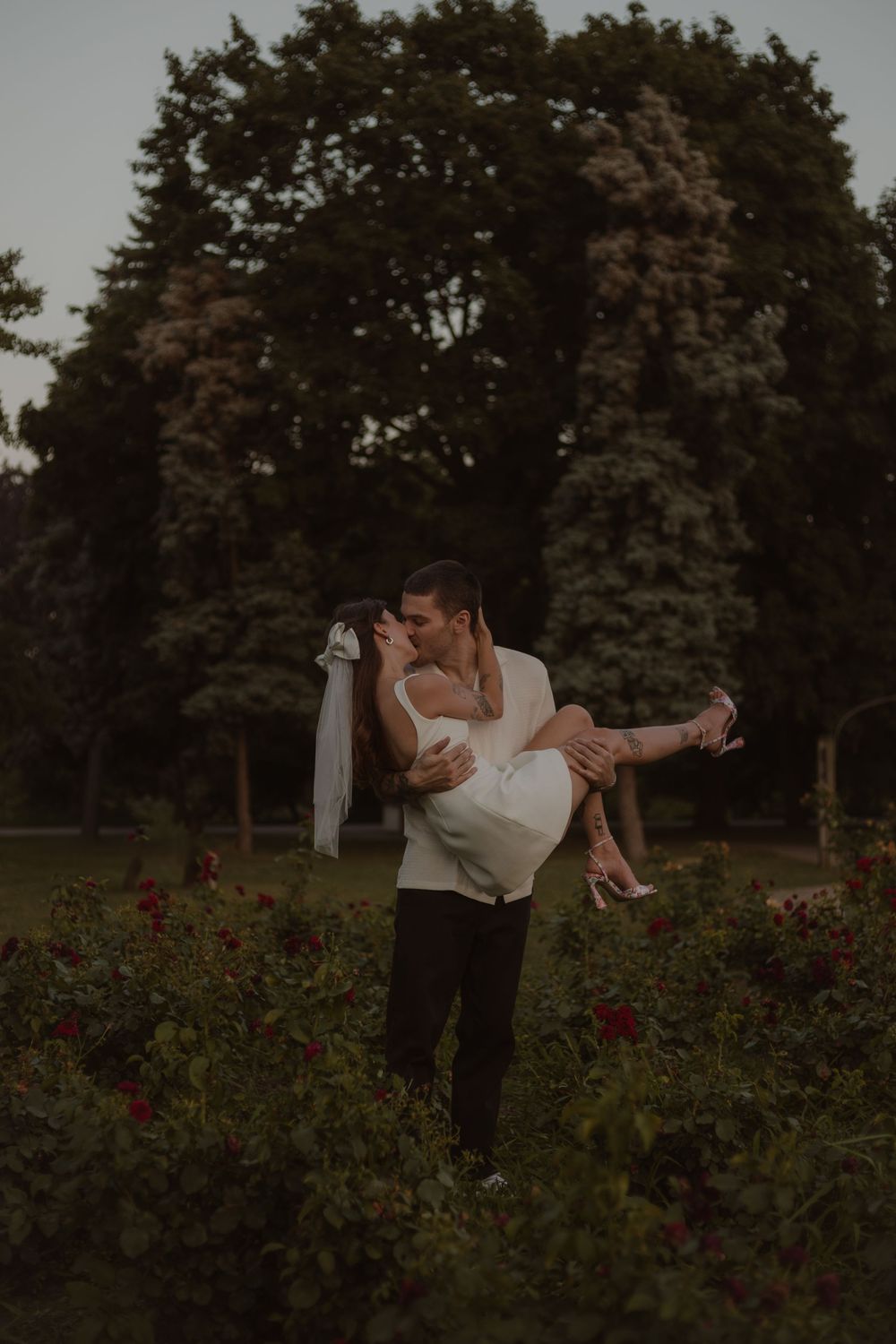 Groom holds bride and swings her around shortly after their vows at Gage park in Hamilton, Ontario.