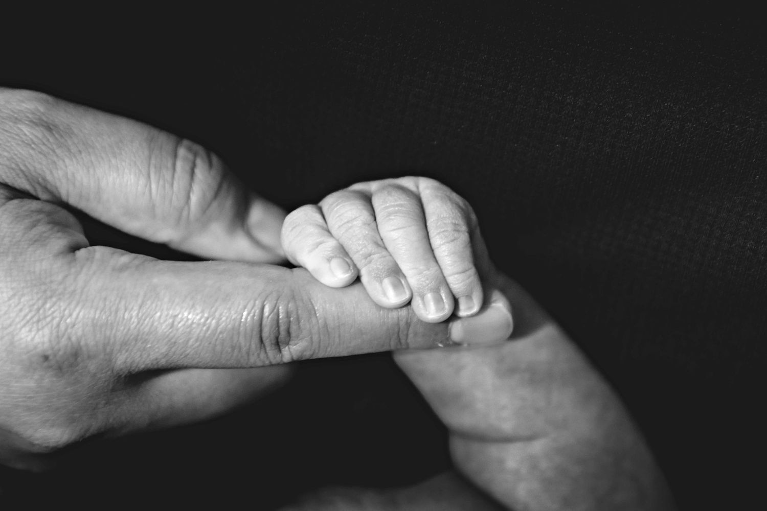 Clovis, Ca newborn holding father's finger. Captured by Fresno, Ca photographer.