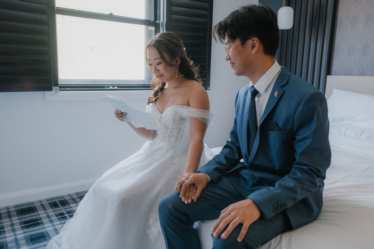 Wedding couple and attendants share intimate moments in a bright modern room.