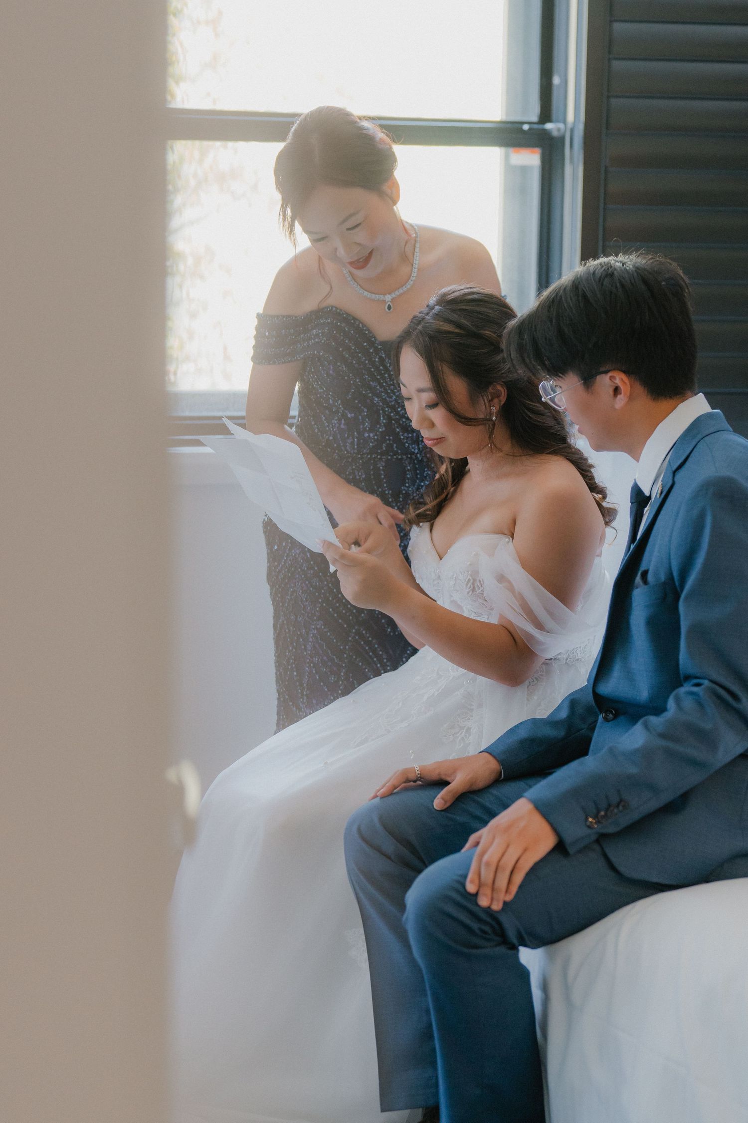A heartwarming moment as wedding party members review documents together in a sunlit room.