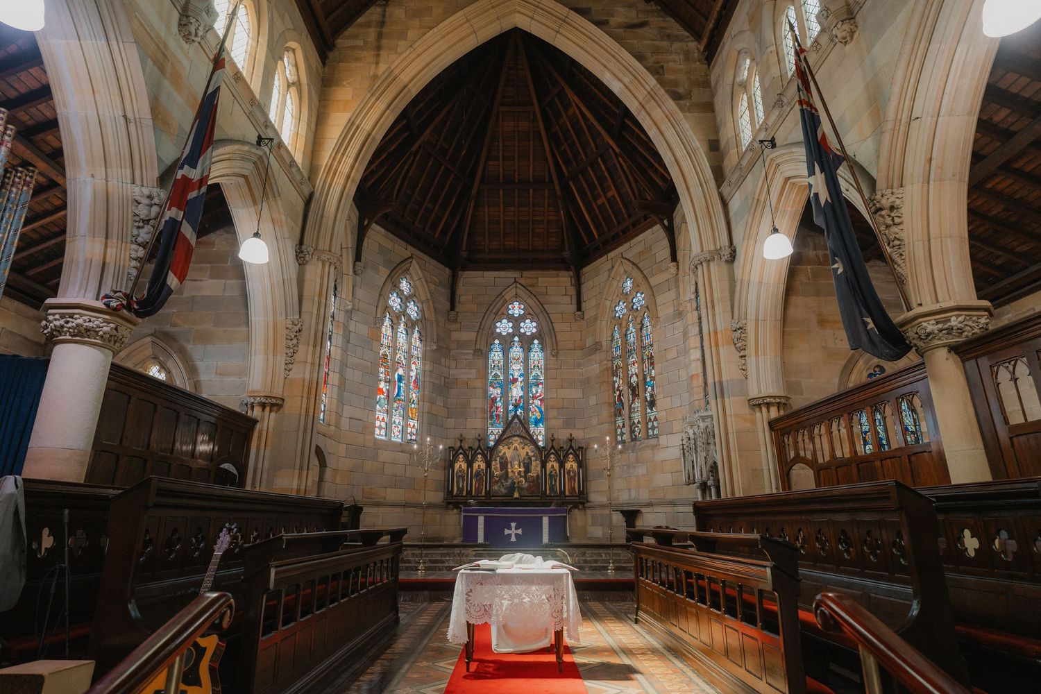 Panoramic view of a church sanctuary with vaulted ceilings and wooden pews.