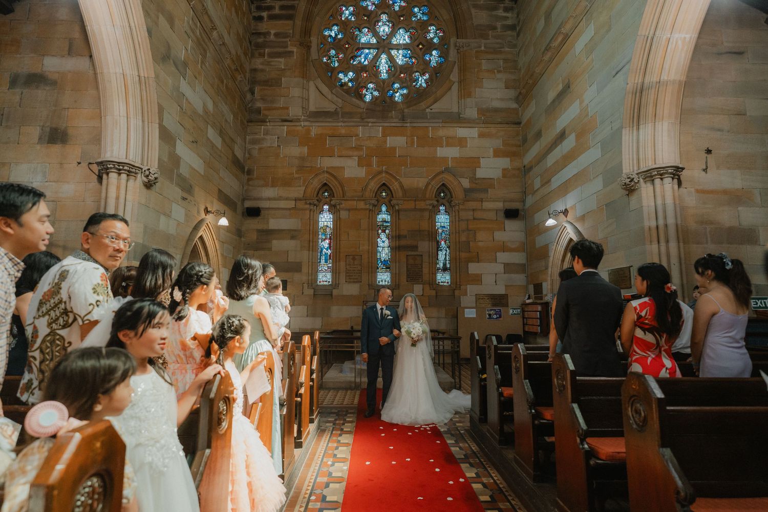 Wedding ceremony in a beautiful cathedral with stained glass windows and ornate architecture.