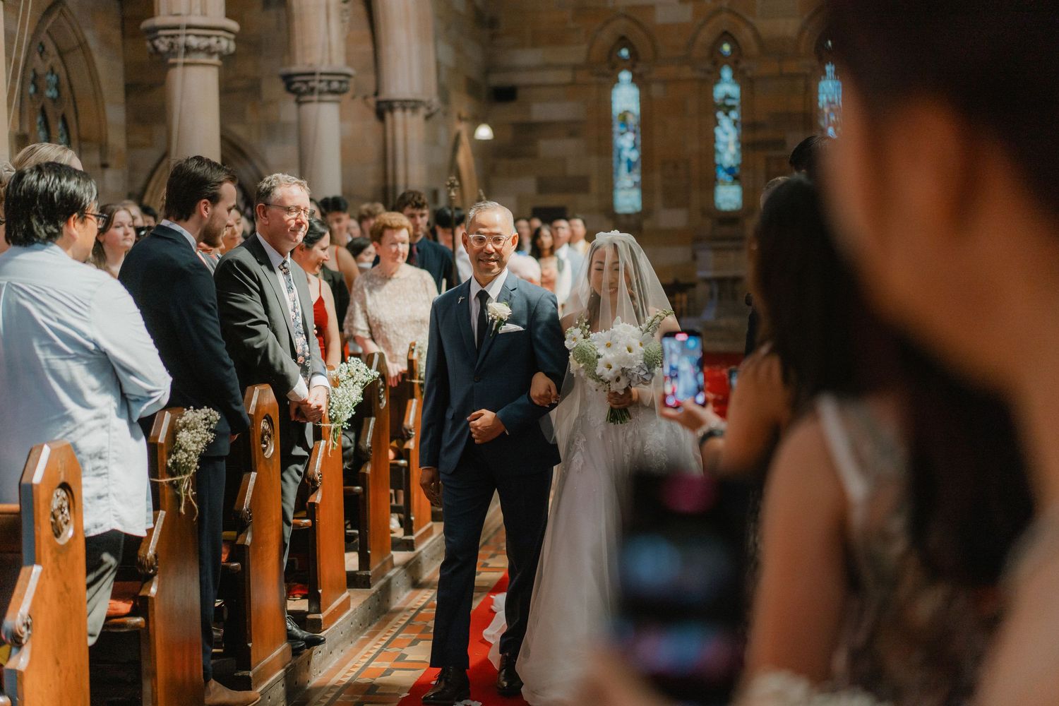 Wedding ceremony in a historic stone church with gothic architecture and stained glass windows.