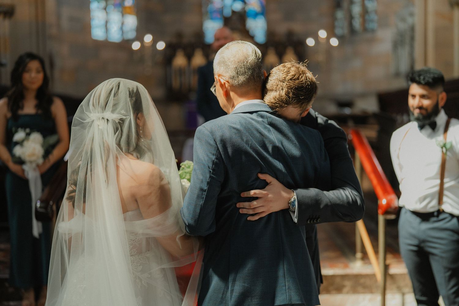 An intimate moment between family members during a church wedding ceremony.