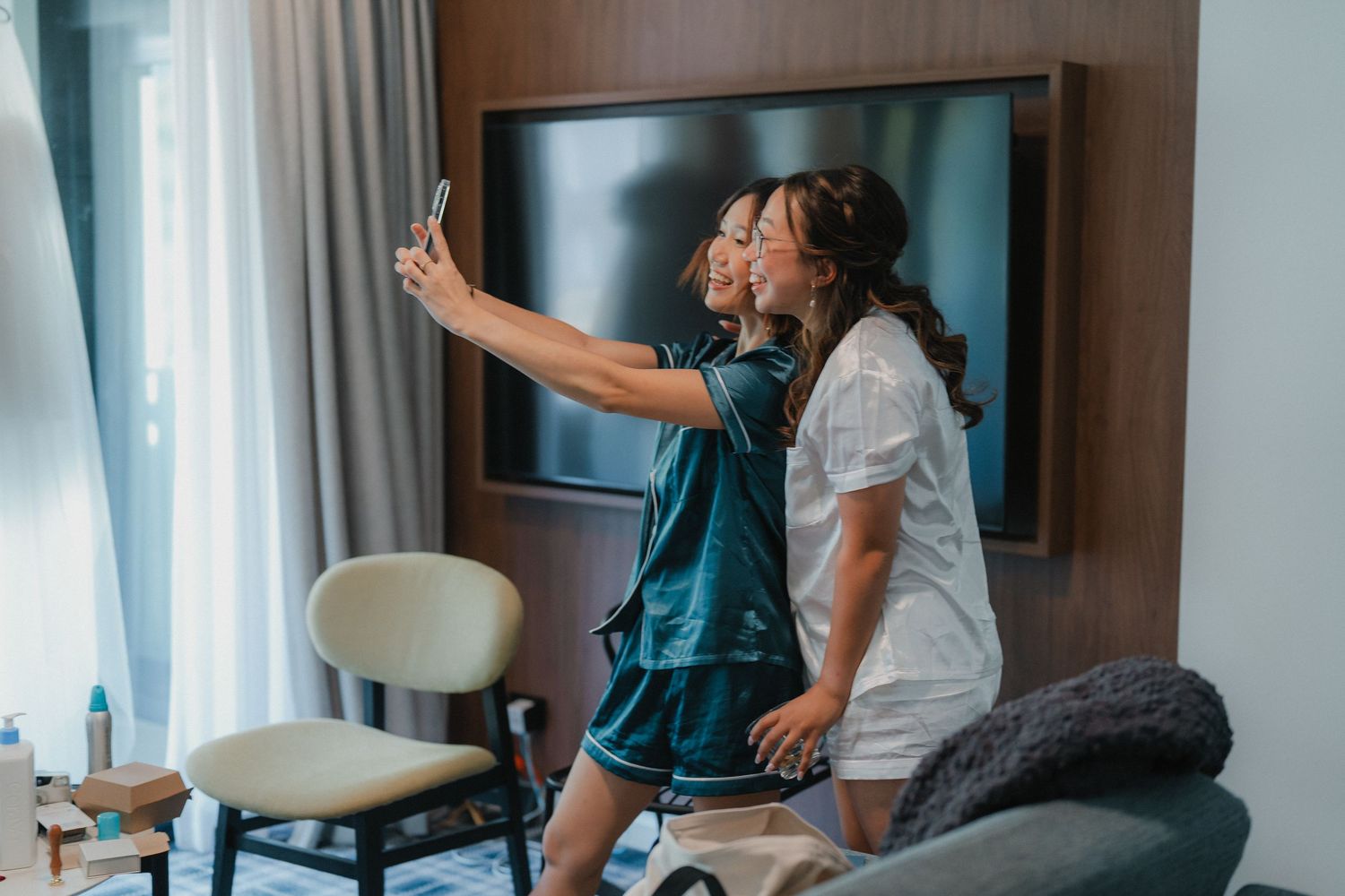 Two friends sharing joy and excitement in a bright living room on a morning.